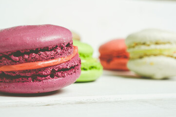 Set of colorful French pasta cakes.  Sweet macaroons with different flavors on a white wooden table...