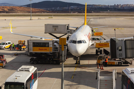 Airbus A320 type airliner parked in service area with ambulift, catering lift and air jetty conntected. Front view. Sabiha Gokcen, Turkey - February 16 2020.