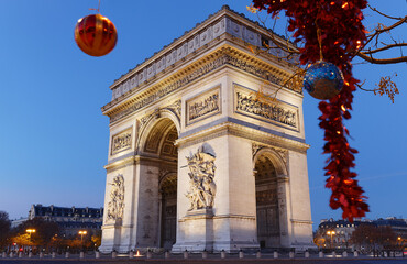 Obraz premium The famous Triumphal Arch at night and Christmas baubles. Paris. France.