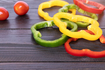 Slices of bell pepper on rustic wooden table background with copy space. 