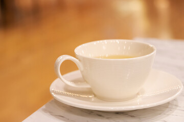 Cup of tea on the table with blur background at cozy cafe and restaurant.