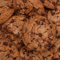 Freshly baked homemade crunchy cookies with chocolate chips, peanut butter or salted caramel. A delicious treat for gourmets. Biscuits close-up. Selective focus, square image