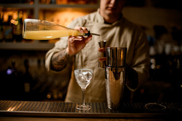 steel glasses of shaker and wine glass with ice are on the bar.