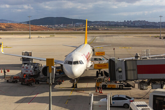 Airbus A320 type airliner parked in service area with ambulift, catering lift and air jetty conntected. Front view. Sabiha Gokcen, Turkey - February 16 2020.