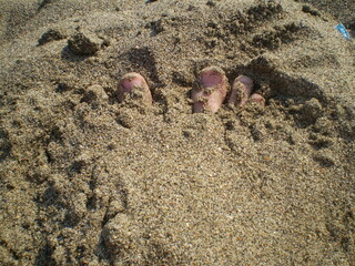 Feet covered in beach sand