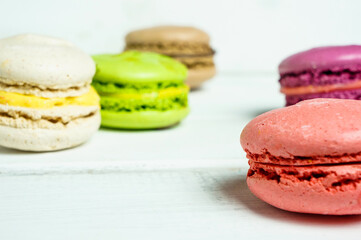 Set of colorful French pasta cakes.  Sweet macaroons with different flavors on a white wooden table...