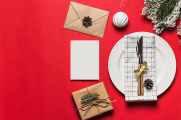 Christmas and New Year holiday table setting with envelope, gift box and blank card decoration. Holiday decoration.
