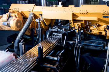 Automatic band saw machine with water coolant cutting metal pipes.