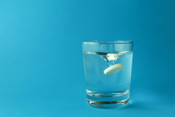 effervescent vitamin C tablet dissolves in water. a glass of water and an effervescent paracetamol tablet. the medicine tablet dissolves in a glass of water