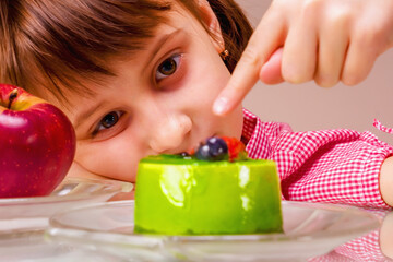 Beautiful young girl eating cake, she prefer sweets than healthy food and fruit. Close up.