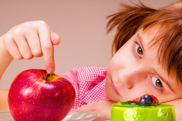 Beautiful young girl having hard choice between healthy and unhealthy food. Horizontal image.