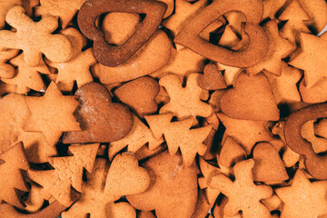 Just baked various shapes gingerbread cookies Christmas tradition background. Hearts, stars, trees,...