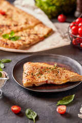 Pizza calzone with cheese and tomatoes, on a dark background, top view