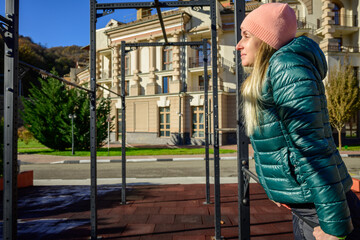 Woman training with horizontal bar at city park