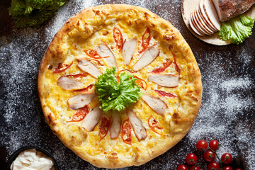 Caesar pizza with chicken breast, mozzarella cheese and tomatoes.