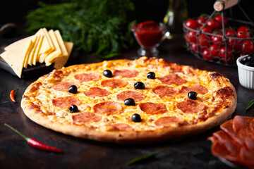 Pepperoni pizza, chorizo on a dark background, top view, flat lay