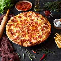 Pepperoni pizza, chorizo on a dark background, top view, flat lay
