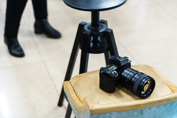 The camera lies on a chair in a photo studio. Creative workshop of the photographer. Selective focus