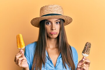 Young hispanic woman wearing summer style holding ice cream depressed and worry for distress, crying angry and afraid. sad expression.