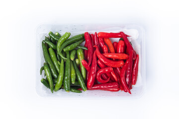 A group of green and red chili without a stalk in a transparent box. Isolated on white background