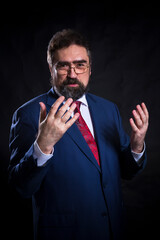 Mature businessman dressed in blue suit with red tie studio portrait.