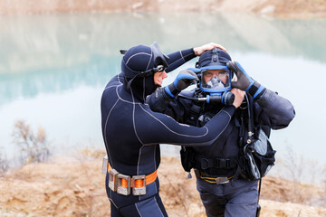 Lifeguard in a wetsuit to work underwater. Search at the bottom of the pond.