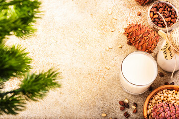 Cedar nut milk, beige table background. Non dairy alternative milk. Healthy vegetarian food and drink concept. Copy space, top view
