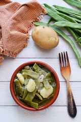 Pods with potatoes in clay pot
