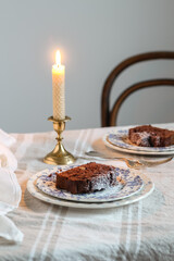 Table served with a chocolate banana cake and a burning candle