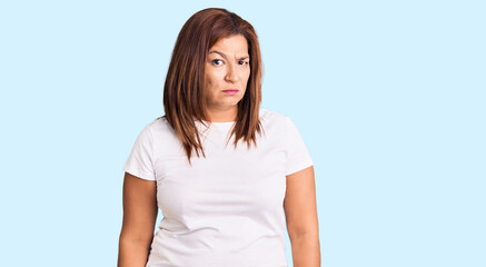 Fototapeta premium Middle age latin woman wearing casual white tshirt skeptic and nervous, frowning upset because of problem. negative person.