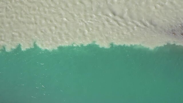 High Angle Aerial View of Muddy and Crystal Clear Turquoise River Water Fusion. Top Down Rising Drone Shot