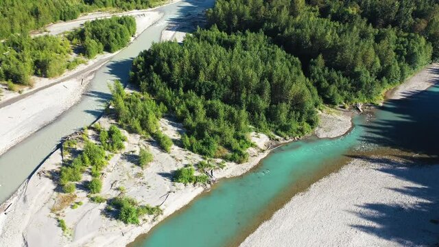 Drone Aerial View of Two Rivers and Green Forest Under Summer Sunlight. Crystal Clear and Muddy Water Junction in Landscape of Washington State USA