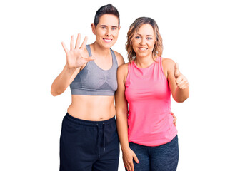 Fototapeta na wymiar Couple of women wearing sportswear showing and pointing up with fingers number six while smiling confident and happy.