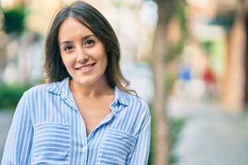 Fototapeta premium Young hispanic woman smiling happy standing at the city.
