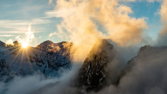 Dramatic sunset above clouds within high alpine peaks, Saas-Fee, Switzerland, Europe
