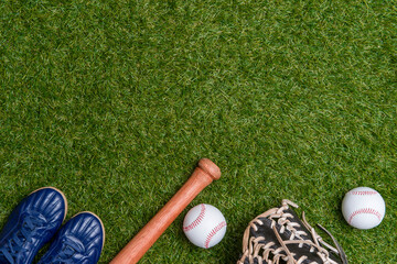Baseball bat,shoes, glove and ball on green grass field.  Sport theme background with copy space...