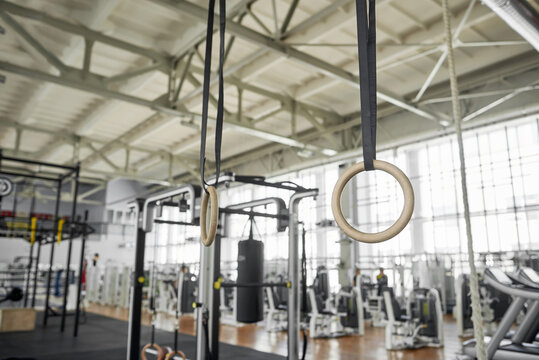 Set of rings on gym background. Gym interior with sport equipment. Muscle training accessory.