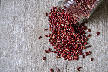 Red beans in glass jar spilled on stone grey background. Eco-friendly organic bio kitchen products. Zero waste sustainable plastic free lifestyle
