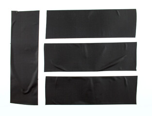 Pieces of black adhesive tape on white background. Black textile cloth sticky tape. Duck tape.