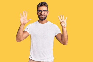 Young hispanic man wearing casual clothes and glasses showing and pointing up with fingers number...