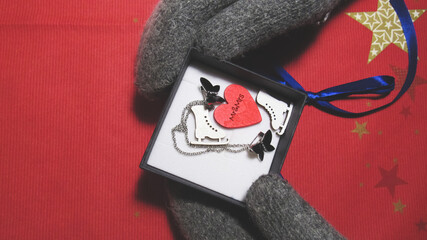 The girl in winter gloves opened the gift. Category: New Year, Valentine's Day, March 8th, Birthday.                       