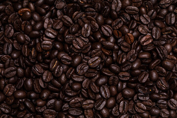 Detailed full frame top view of dark brown coffee beans.