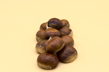 In the foreground on a white background a group of chestnuts. The basis of autumn cuisine.
