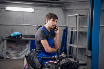 Fototapeta na wymiar A machinist talking to a client on the phone about a motorcycle