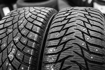 closeup of the tread of two different studded winter tires