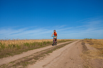 A man riding a bicycle on a rural road
