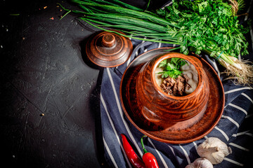 Homemade potato pancakes served with mushroom sauce and mushrooms in ceramic bowl on dark background