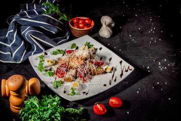 Healthy grilled chicken Caesar salad with tomatoes, cheese and croutons on dark background