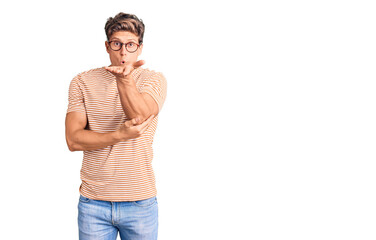 Fototapeta premium Young handsome man wearing casual clothes and glasses looking at the camera blowing a kiss with hand on air being lovely and sexy. love expression.