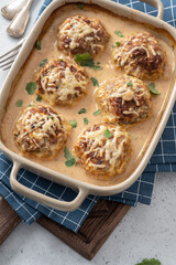 Baked meatballs with cabbage and rice with sour cream sauce